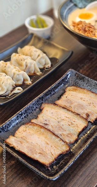 Fototapeta Kanuni pork and Gyoza in black sauce serving with spicy ramen