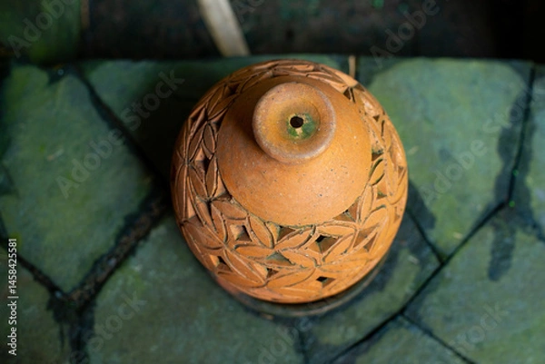 Fototapeta Beautiful oriental decorative terracotta lantern on paved stone floor, with shallow depth of field