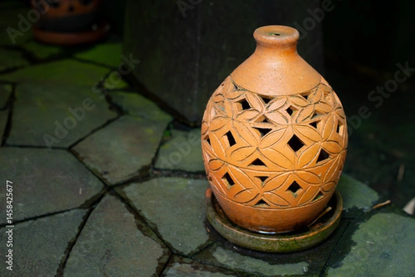 Fototapeta Beautiful oriental decorative terracotta lantern on paved stone floor, with shallow depth of field