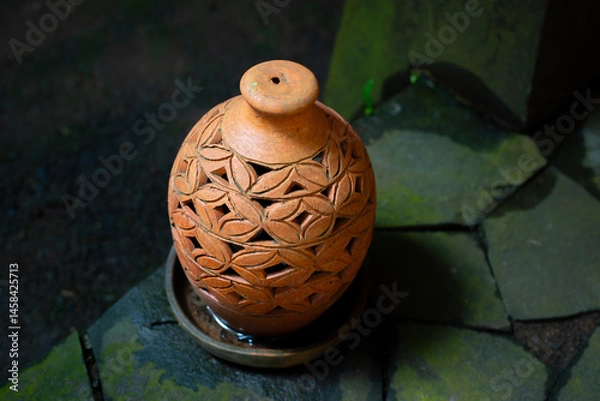 Fototapeta Beautiful oriental decorative terracotta lantern on paved stone floor, with shallow depth of field