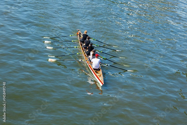 Obraz Academic rowing, four athletes with a coxswain sail in a boat on open water. Academic rowing competition.