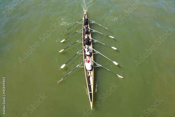 Obraz Academic rowing, four athletes with a coxswain sail in a boat on open water. Academic rowing competition.