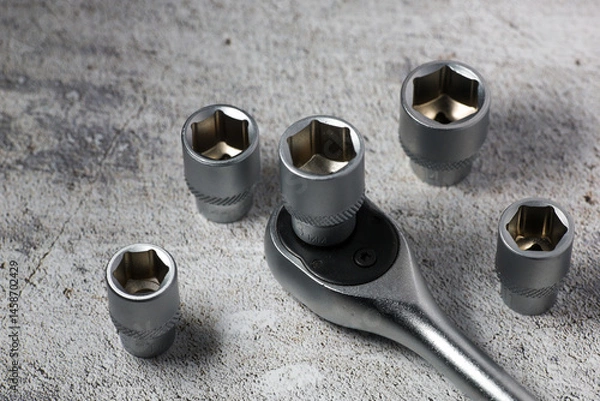 Obraz Ratchet wrench with interchangeable heads of different sizes on a gray background