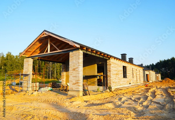 Obraz Homebuilding. Luxury House building. Villa construction. Bricks house under construction. Construction of modern house. Home renovation, reconstruction. Private Home building. Build Suburb house.