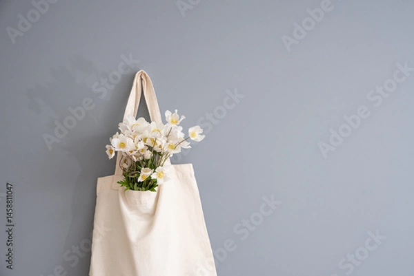 Fototapeta Wildflowers in a reusable fabric vintage bag on a gray background. Eco-friendly and natural. Plastic-free and waste-free.