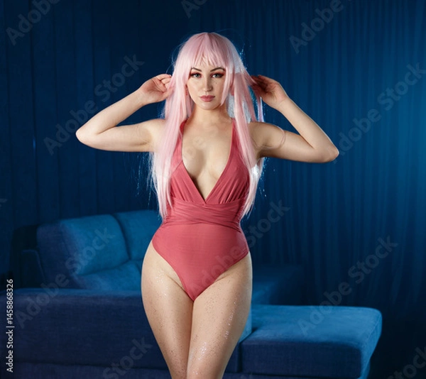 Fototapeta Beautiful blonde posing in erotic pose. Girl in pink bodysuit on sofa.