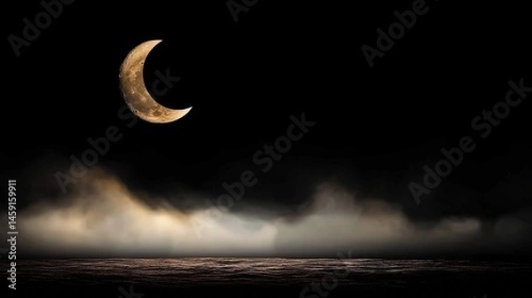 Fototapeta A pale crescent moon rising above a dark, misty horizon.