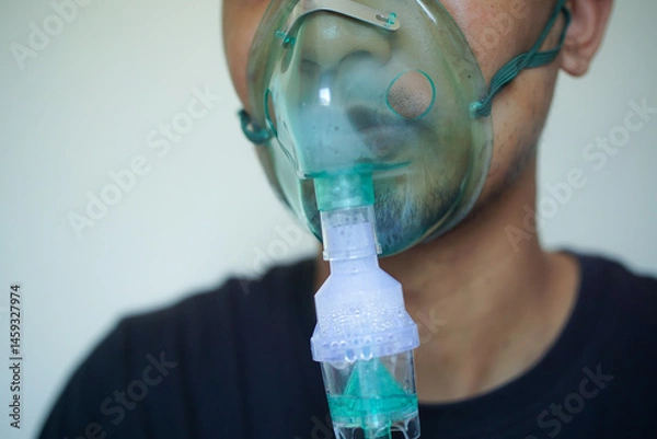 Fototapeta Close up Young man using nebulizer for asthma and respiratory diseases at home