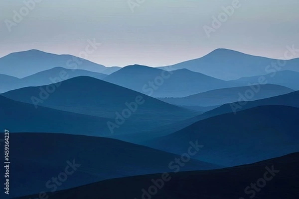 Fototapeta Misty mountain range, soft blue tones.  Layers of peaks fade into the distance