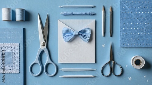 Obraz Flat lay of crafting supplies including scissors, paper, and embellishments on blue surface