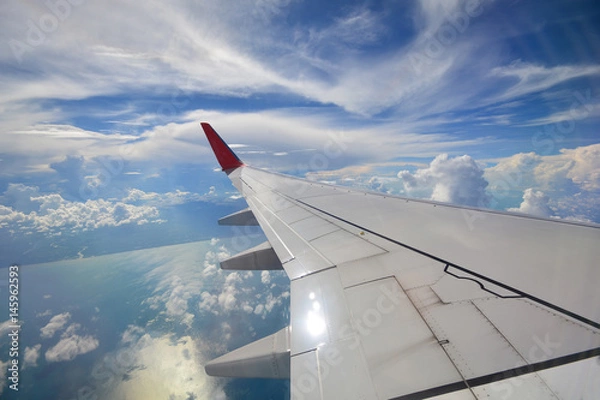 Fototapeta View of beautiful cloud and wing of airplane from window, South of Thailand