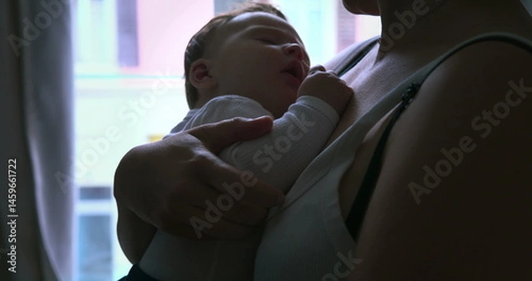 Fototapeta Close-up of a mother cradling her baby against her chest, providing warmth and security as the baby sleeps peacefully in her arms