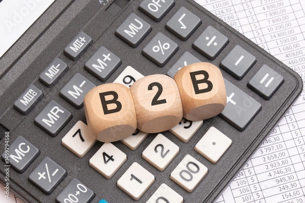 Obraz B2B letters on wooden cubes placed on calculator and financial spreadsheet