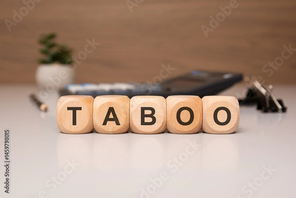 Obraz Wooden blocks spelling TABOO on a desk in office setting.