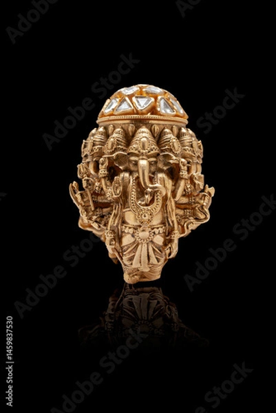 Obraz A close-up of a golden ring featuring an intricate design of the Hindu God Ganesh, adorned with multiple diamonds on top, set against a black background.