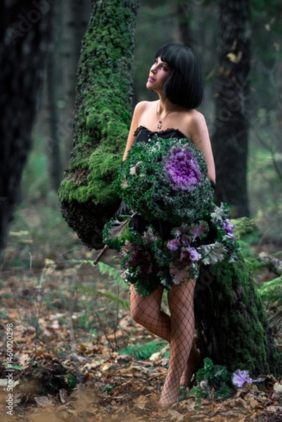 Fototapeta Slender beautiful brunette in the image of a forest fairy in full growth. Decorative cabbage instead of a bouquet. Artistic creative photography.