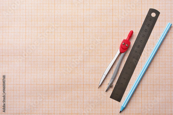 Fototapeta Concept of studying at school and back to school. Pens, pencils and ruler on school squared paper background, copy space