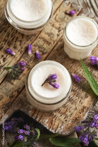 Fototapeta Jars of homemade comfrey root ointment with fresh symphytum plant