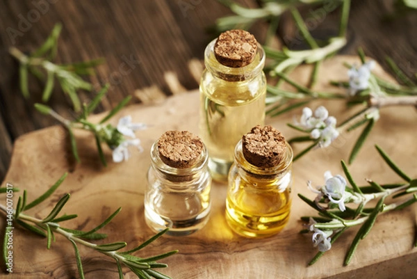 Fototapeta Three bottles of rosemary essential oil on a table