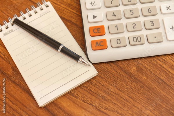 Fototapeta Blank notebook with pen and calculator on wooden table, business concept