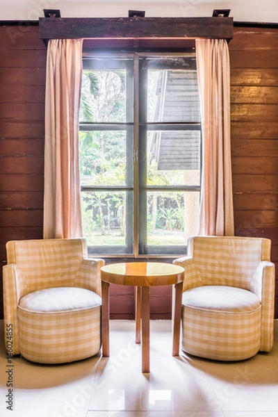 Fototapeta Classic twin fabric sofas and wooden round table. Interior design with window and curtains.