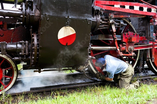 Obraz Mechanik przy pracy na tle parowozu.