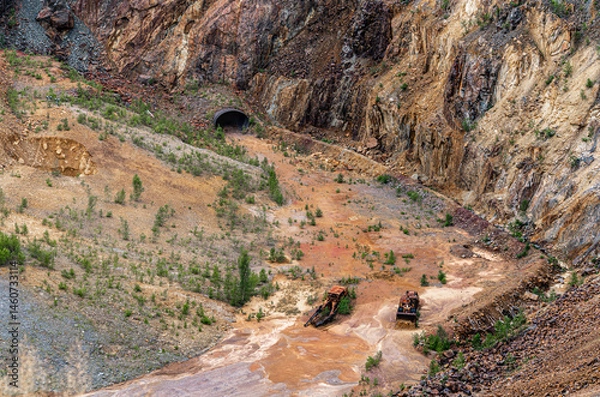 Fototapeta Explore the former copper mine in Falun, Sweden, where two rusted bulldozers lie abandoned amid the colorful mineral landscape, capturing the essence of a historical site