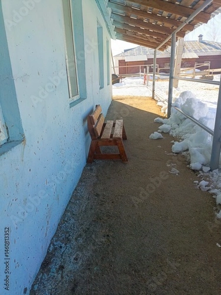 Obraz Rustic Wooden Bench in Neglected Winter Setting Against Speckled Blue Wall