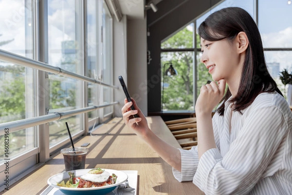 Obraz カフェでスマホを使う女性
