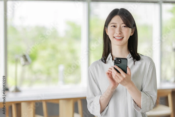 Obraz スマホを持つ若い女性
