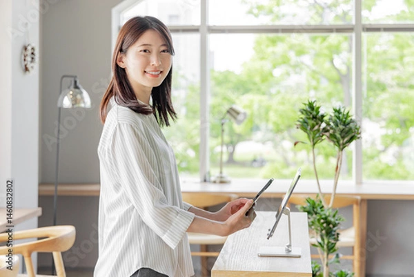 Obraz ホテルで受付をする若い女性　タブレット　セルフチェックイン
