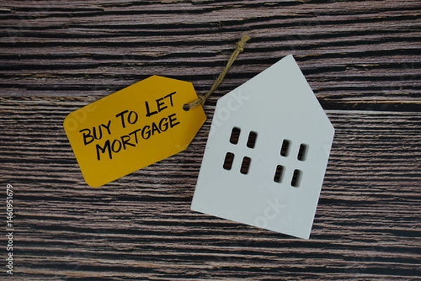 Fototapeta Buy To Let Mortgage text on price tag with white house model flat lay on wooden background