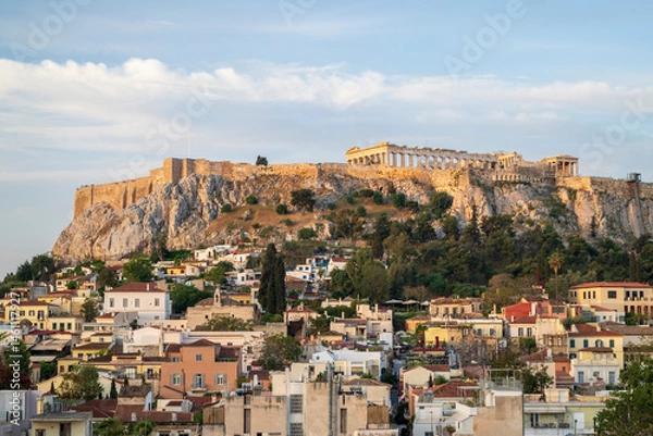 Fototapeta View of the Acropolis, in Athens, overlooking the old city, as the early morning light illuminates the buildings and the Parthenon