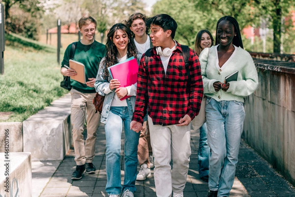 Fototapeta Happy diverse students walking and talking on university campus