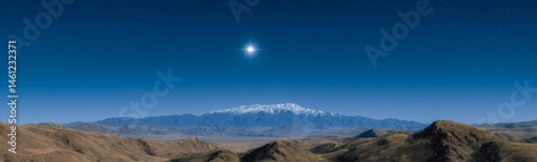 Obraz Celestial Heights: A breathtaking landscape showcasing a majestic snow-capped mountain range under a brilliant star in a clear, cerulean sky. A harmonious blend of earth and sky.