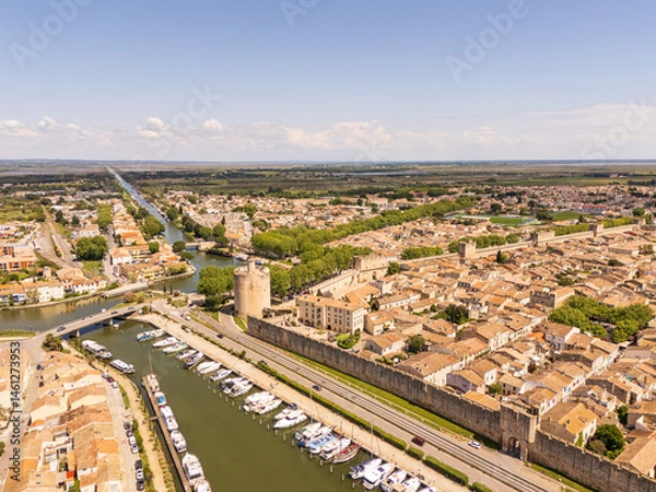 Fototapeta Aigues-Mortes, Camargue, France, medieval city with its surrounding walls, the Constance Tower, and typical southern french houses, canals for boats