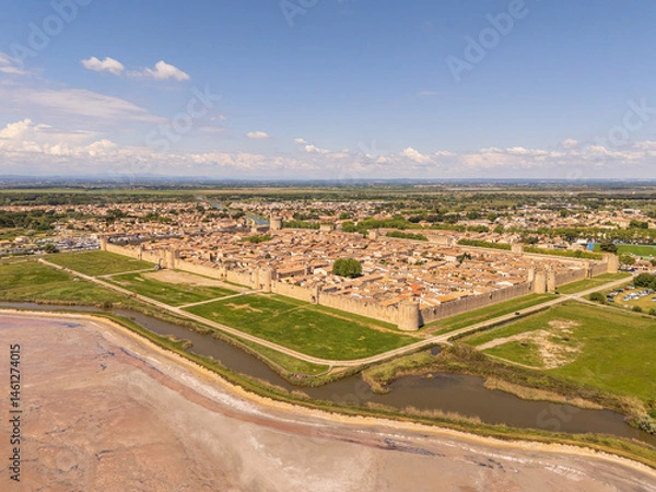 Fototapeta Aigues-Mortes, Camargue, France, medieval city with its surrounding walls, the Constance Tower, and typical southern french houses, canals for boats