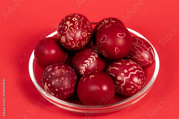 Fototapeta Red-painted Easter eggs on a glass plate on a red background