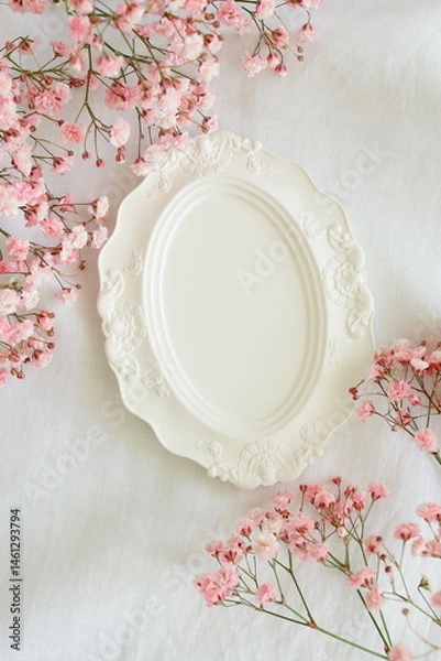 Fototapeta Top view white vintage empty plate mockup and pink gypsophila flowers frame on white linen texture background. Copy space. Holiday backdrop