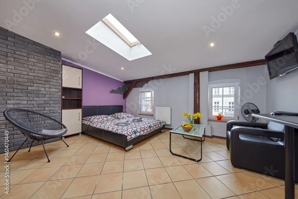 Obraz Kolorowy apartament na poddaszu z dużym łóżkiem i aneksem kuchennym