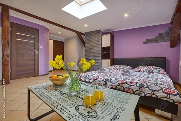 Obraz Kolorowy apartament na poddaszu z dużym łóżkiem i aneksem kuchennym