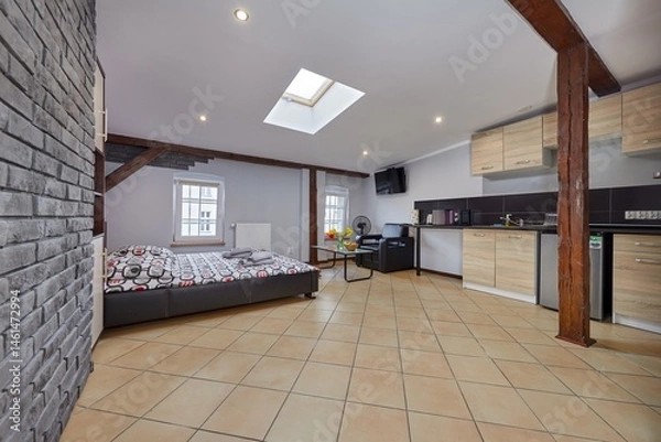 Obraz Kolorowy apartament na poddaszu z dużym łóżkiem i aneksem kuchennym