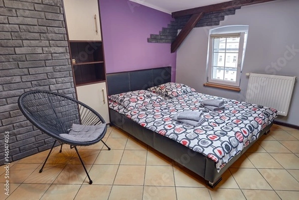 Obraz Kolorowy apartament na poddaszu z dużym łóżkiem i aneksem kuchennym