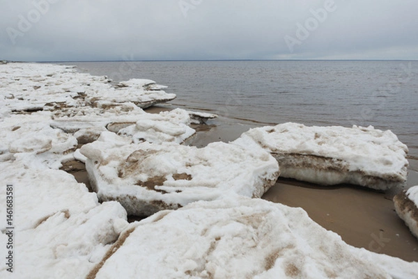 Obraz A beautiful snowy beach scene featuring a body of water in the background