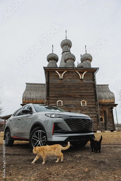 Obraz A car is currently parked in front of a wooden building structure