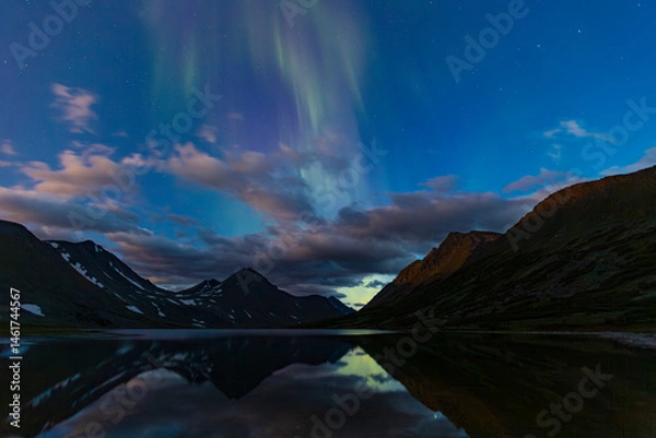Fototapeta Aurora in the night sky cut the mountains, reflected in the water. Yamal. Russia