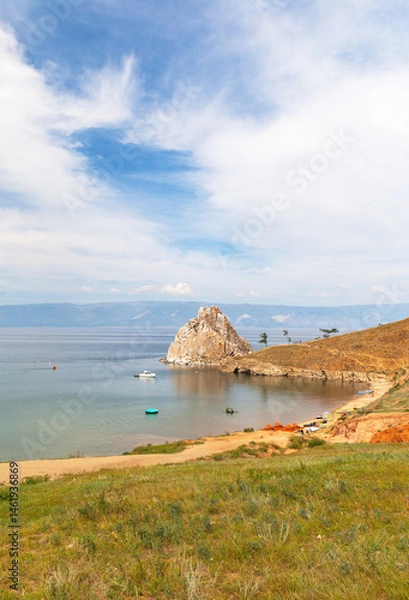 Fototapeta Lake Baikal in summer. Tourists relax at famous Shamanka rock, ride SUP boards, water bikes, pleasure and rubber boats on sunny August day. Cape Burkhan - natural landmark of Olkhon Island