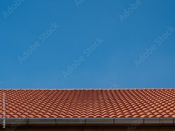 Obraz red tile rooftop on blue sky background