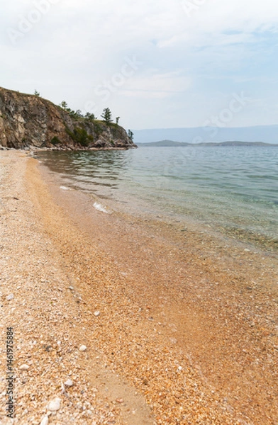 Fototapeta Lake Baikal on quiet summer day. Landscape of shore of Small Sea with sandy and pebble beach and clean transparent water near Olkhon Island. Summer travel and vacation. Natural seaside background
