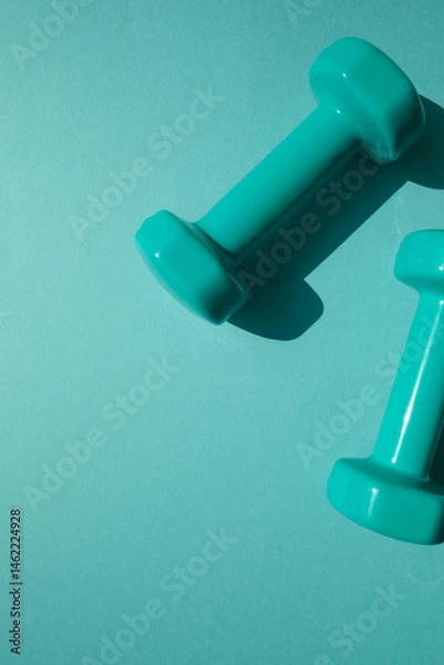 Obraz Sport or workout concept flat lay with blue dumbbells on the blue teal background. Copy space